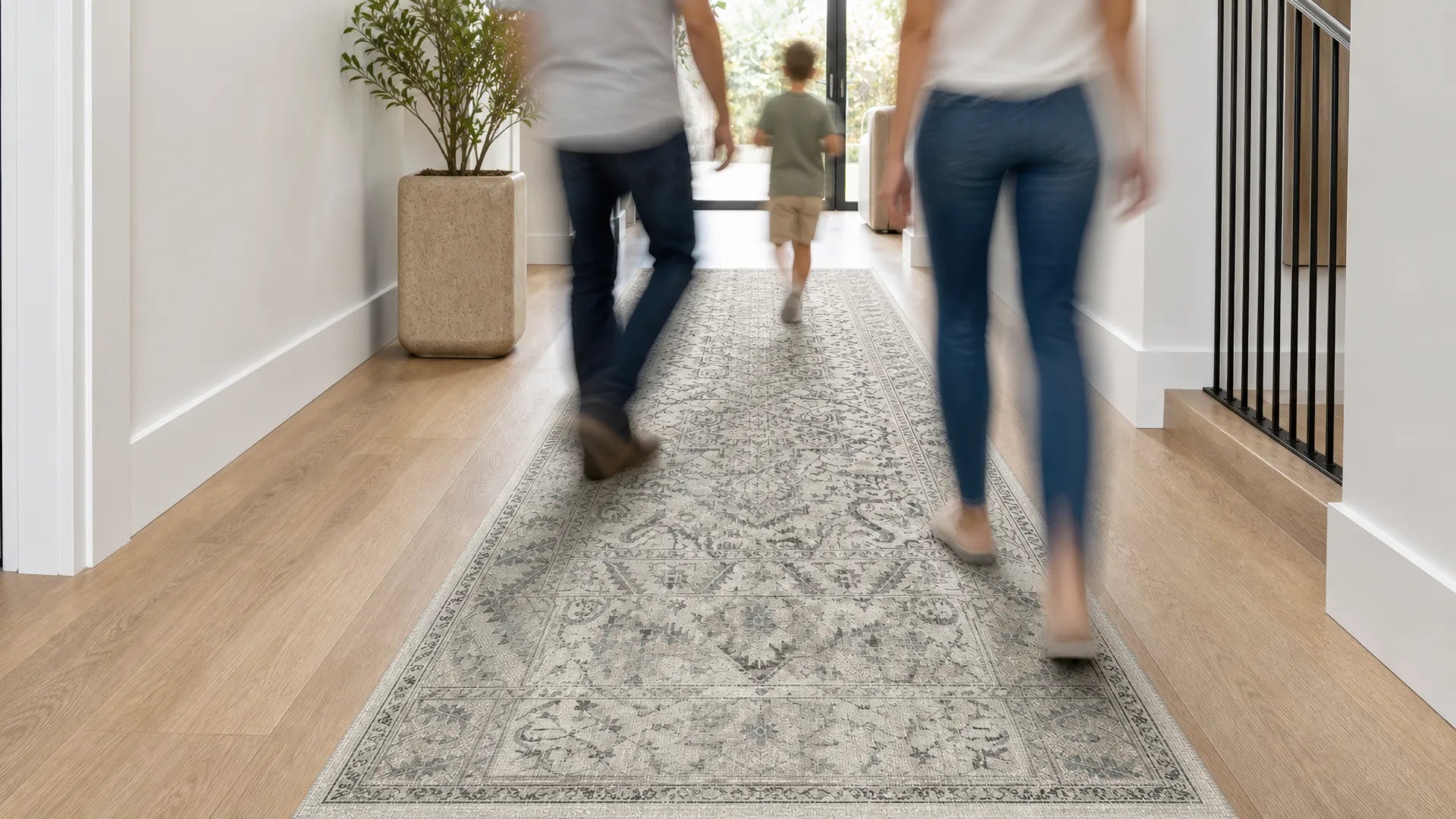 A stylish rug on hallway and family walking on the rug. A high traffic hallway with beige, stylish rug.