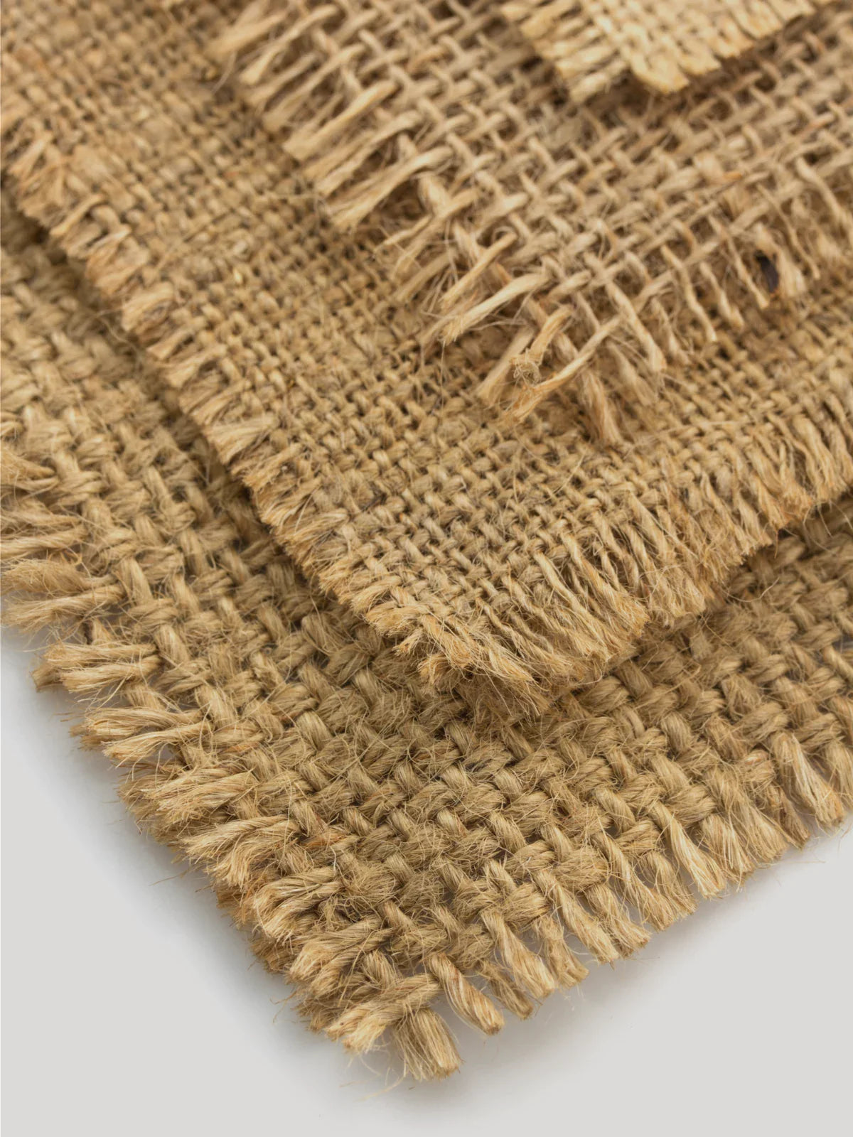 Close-up of a 6x9 jute rug with intricate woven texture and fringed edges, showcasing its natural fiber construction.