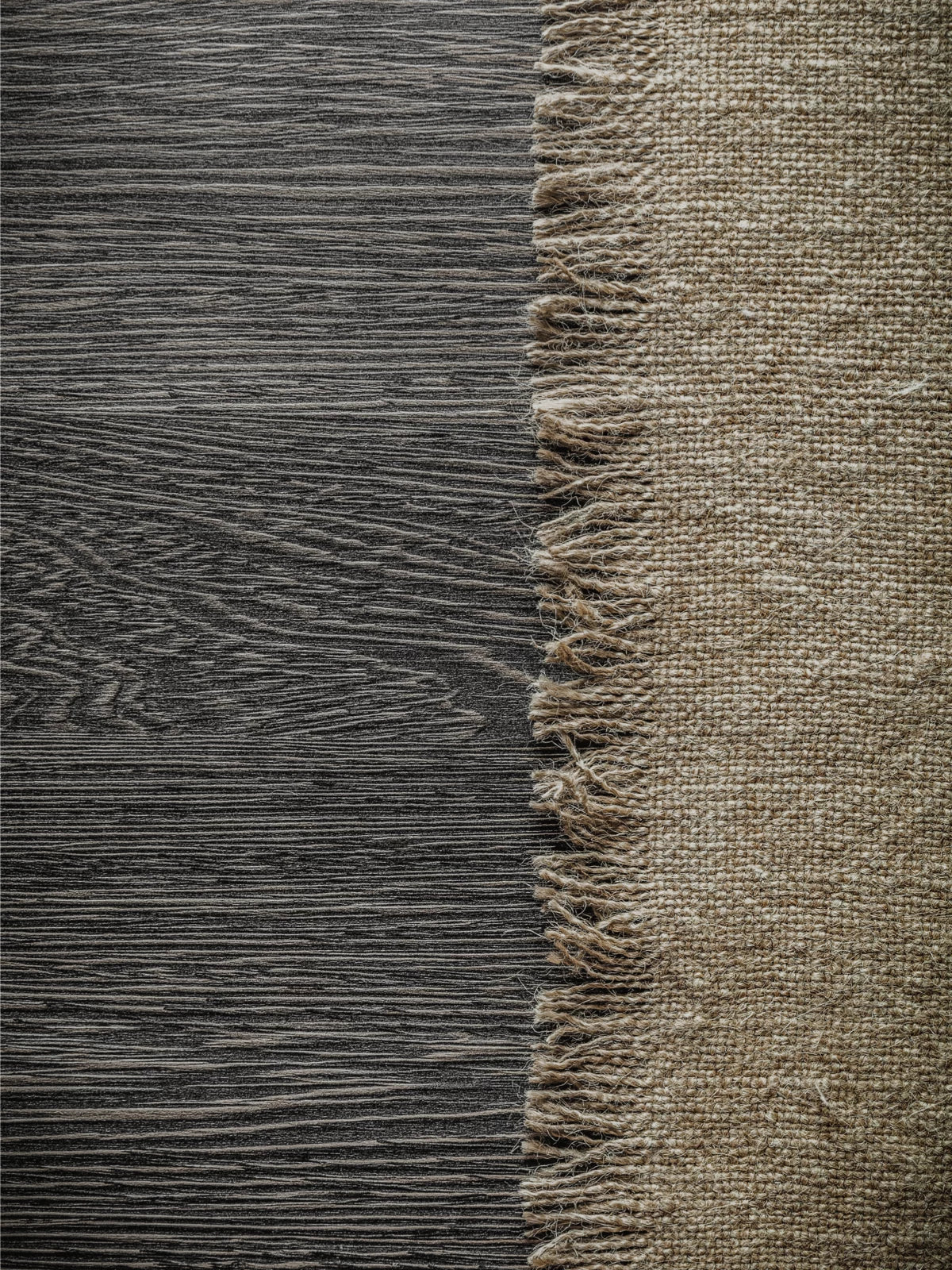 Close-up of a 4x6 jute rug with fringed edges, placed on a dark wooden floor, showcasing its natural woven texture and rustic charm.