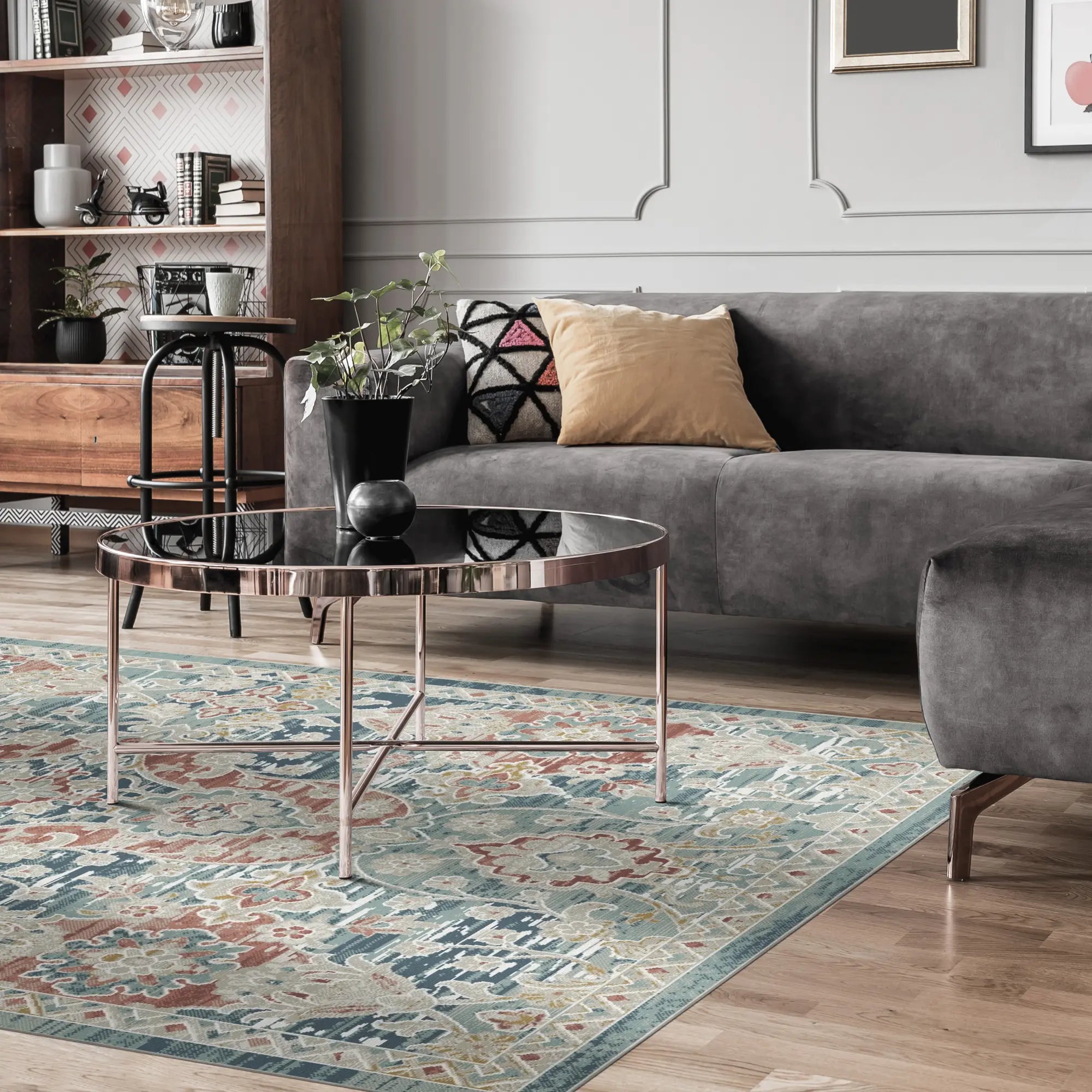 area rug with blue, beige, and rust floral damask pattern on wood floor in living room