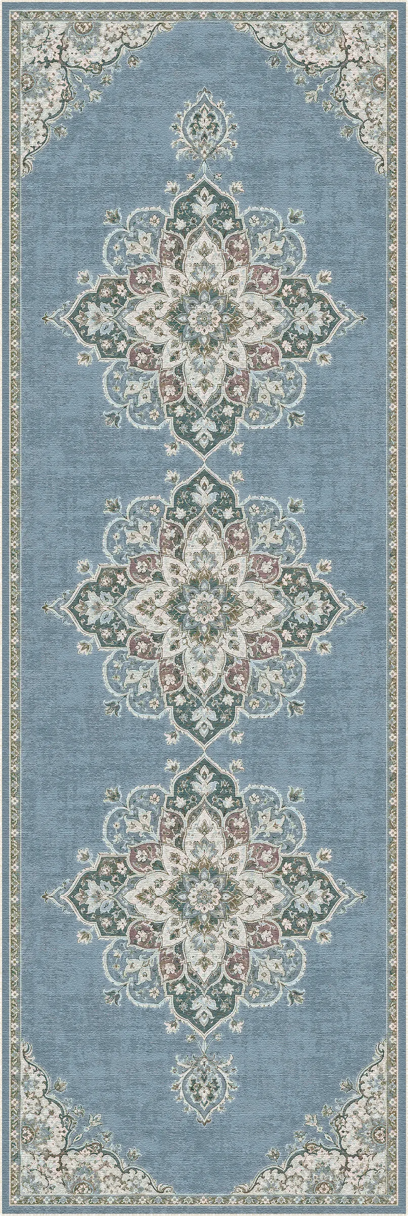 A long rectangular area rug with a light blue field and ornate symmetrical medallion motifs in cream, beige, muted green, and dusty pink, bordered by a detailed cream and beige patterned edge.
