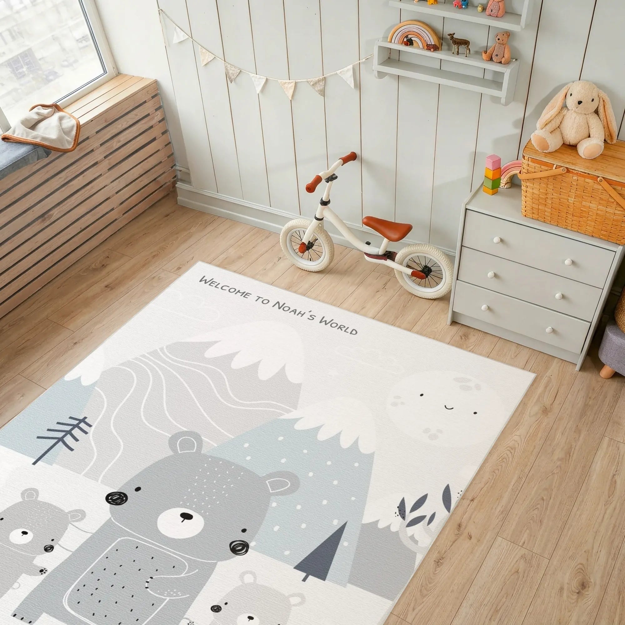 Children's room with a rug featuring bear illustrations, a balance bike, and toys.