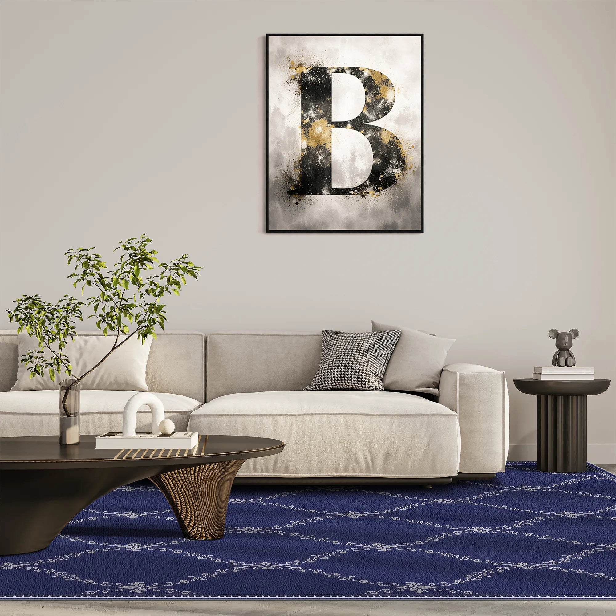 A blue lattice washable rug with a framed abstract wall art print featuring a large textured letter B in black, white, and gold tones, displayed above a modern light beige sofa in a styled living room setting with a blue patterned rug, dark coffee table, and side table.