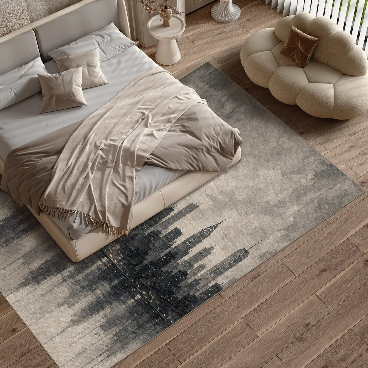 A large rectangular New York City area rug with a gray and black abstract city skyline design, styled in a modern bedroom setting next to a bed and a cloud-shaped pouf chair.