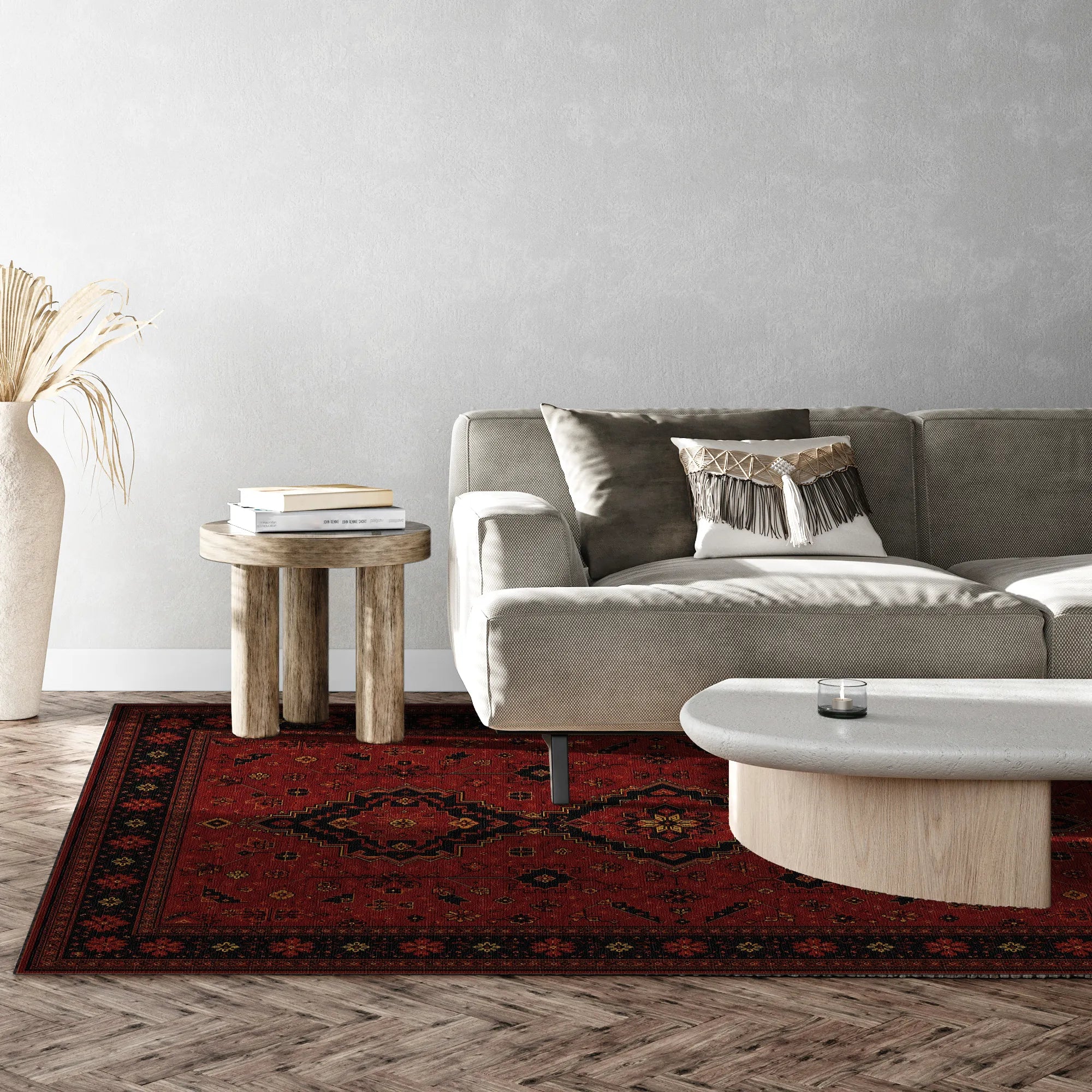 A red and black patterned area rug styled in a modern living room setting with a gray sofa, wooden side table, and light-colored coffee table.